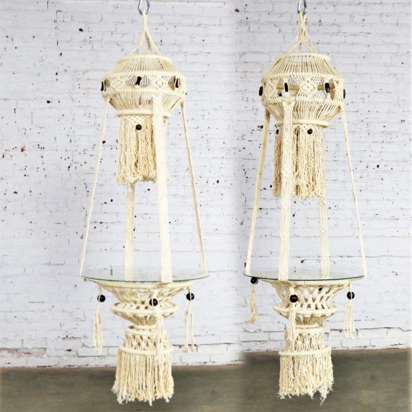 Beautiful pair of white cord macramé hanging tables with round glass tops. They are in wonderful age appropriate condition but not without minor flaws which do not take away from their overall look. Please examine photos. Circa 1960s-1970s.